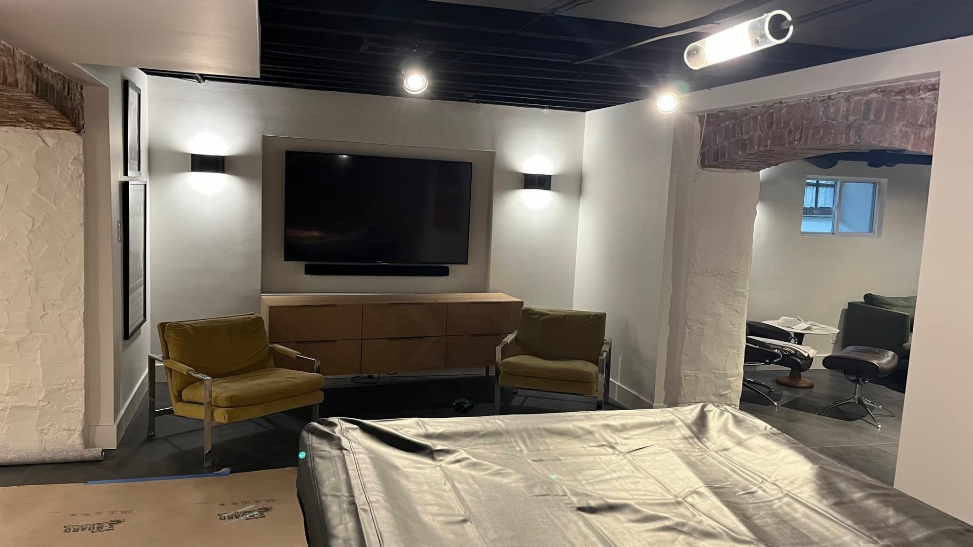 Basement lounge with mounted TV, custom lighting and millwork