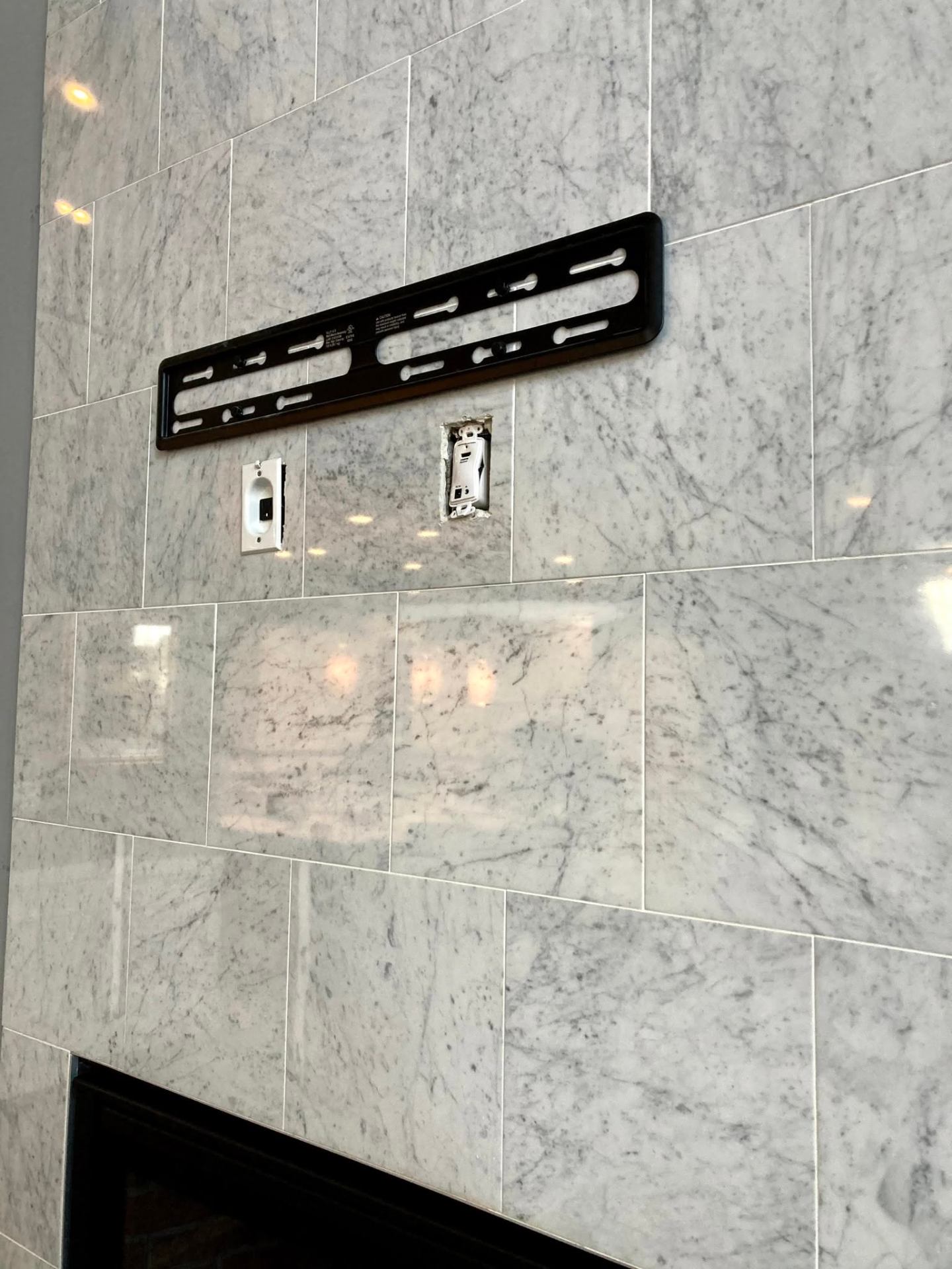 Marble accent wall prepped for flush TV mount with hidden power
