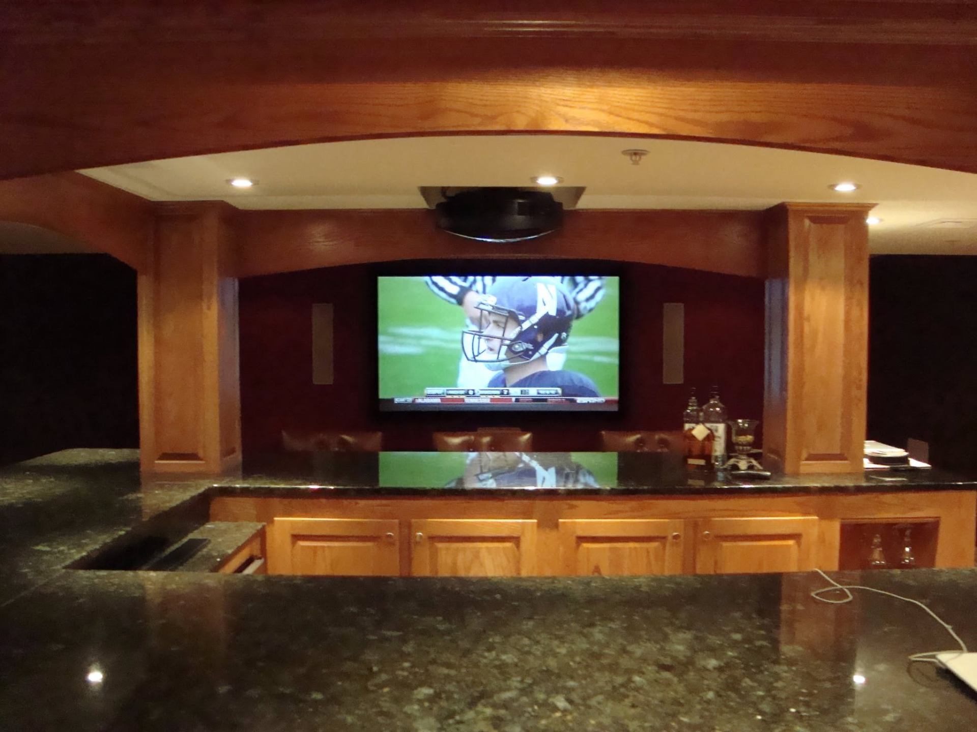 Large TV installation above home bar with hidden wiring