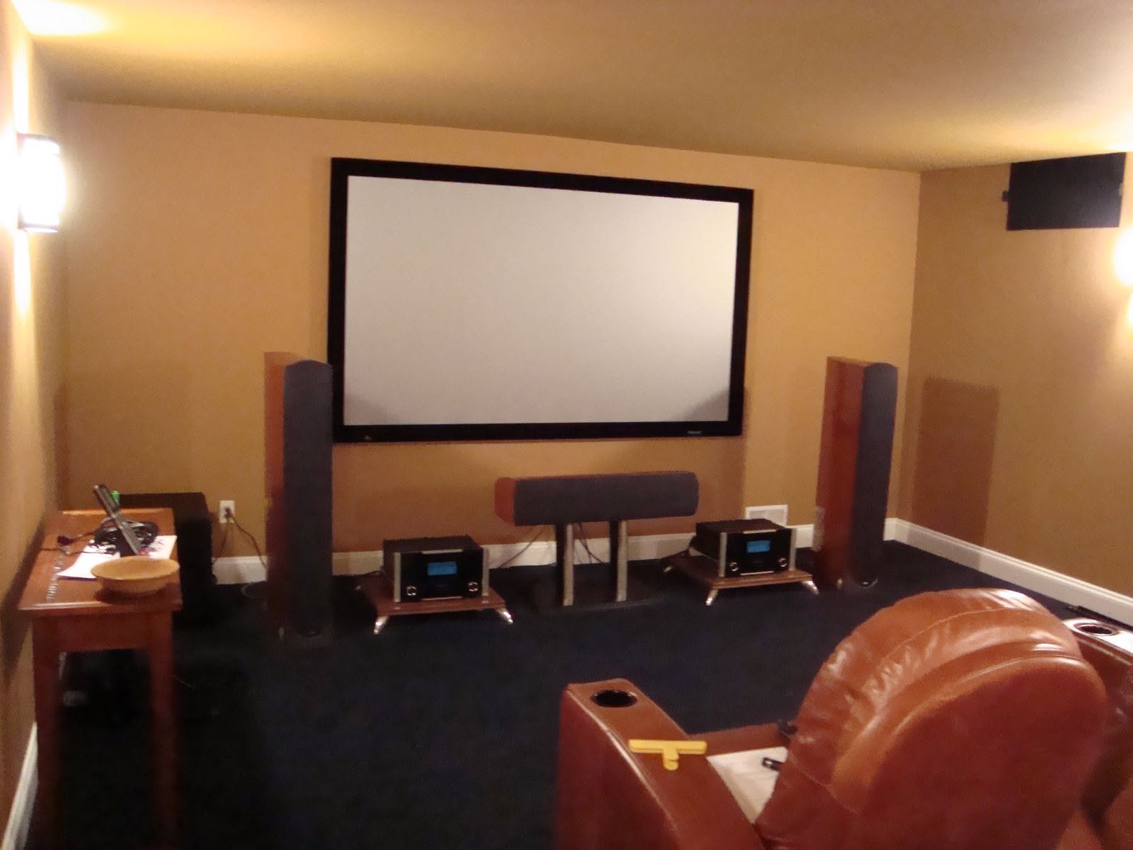Fixed-frame projection screen with tower speakers and center channel